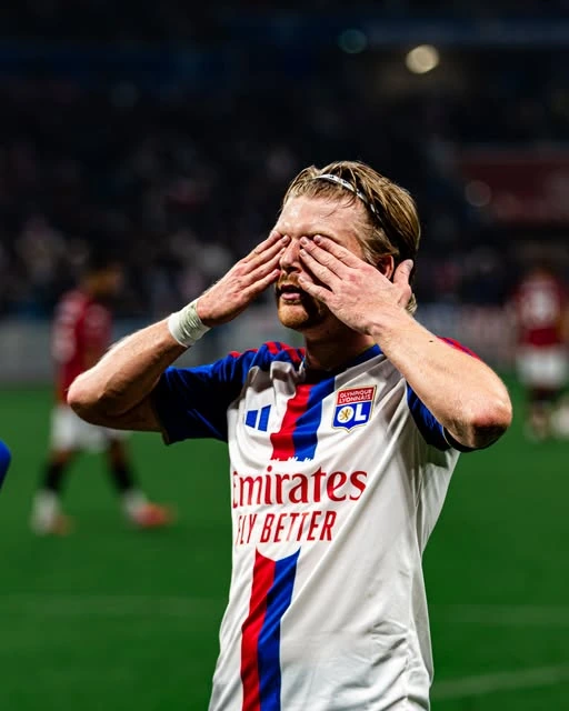 Joueur de football en maillot blanc, les mains sur le visage