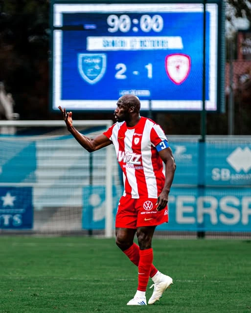 Joueur en rouge et blanc sur le terrain à la fin du match
